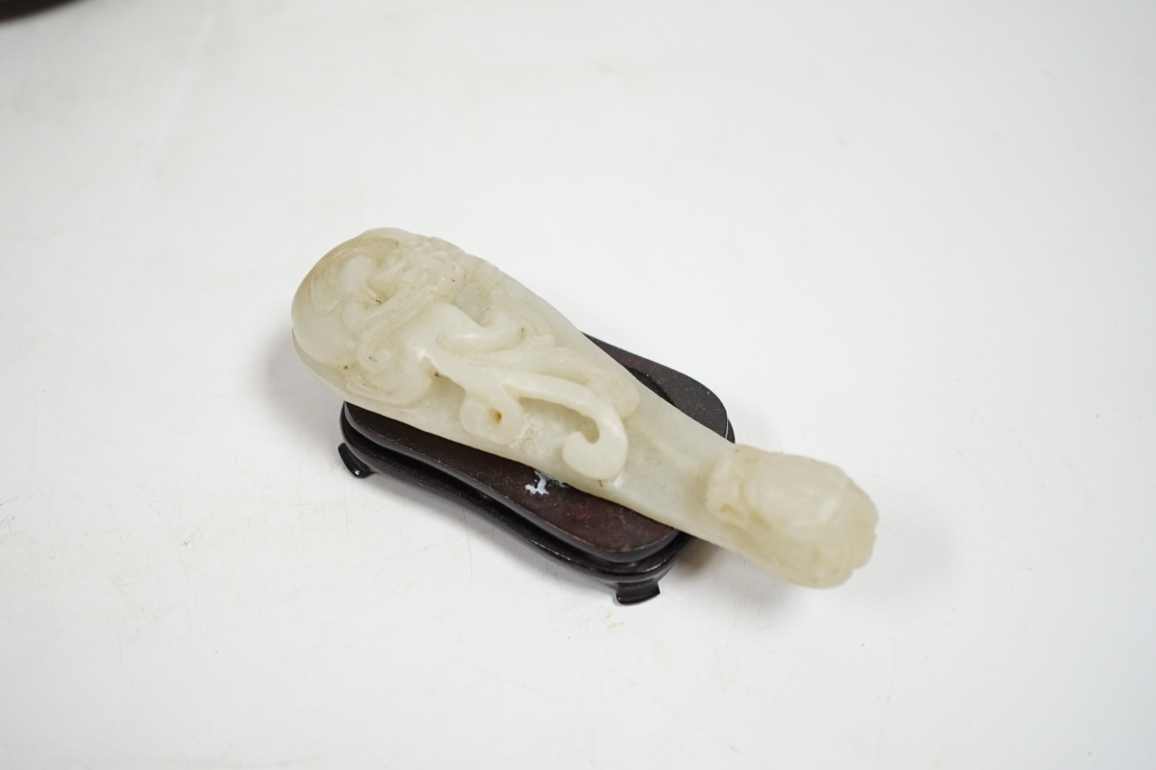 A Chinese pale celadon and grey jade mythical beast on stand, and a pale celadon jade belt hook, mythical beast 11cm wide